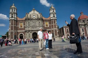 Archbishop Joseph E. Kurtz, of Louisville, Ky., president of the United States Conference of Catholic Bishops, takes a photo of a family in front of the Basilica of Our Lady of Guadalupe in Mexico City Nov. 16. Archbishop Kurtz was in Mexico City with other leader s from the Americas who met Nov. 16-19 to discuss the new evangelization in the Americas. (Catholic News Service photo/David Maung)