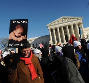 A man holds a poster outside the U.S. Supreme Court during last year's March for Life in Washington. (CNS file/Leslie Kossoff)