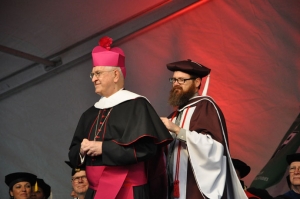 Dr. Gregory Hillis, associate professor of theology at Bellarmine, assisted Archbishop Joseph E. Kurtz with his academic garb. Archbishop Kurtz received an honorary doctoral degree at the ceremony. (Record Photo by Jessica Able)